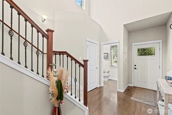 a view of staircase with lots of frames on wall and wooden floor