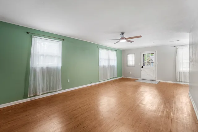 a view of a livingroom with wooden floor and a ceiling fan