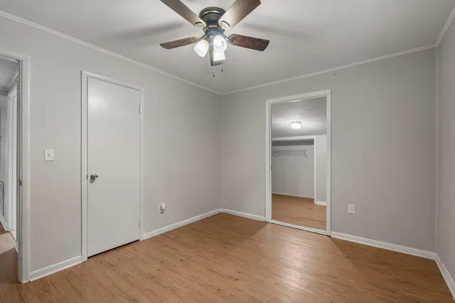 a view of an empty room with a chandelier fan