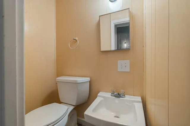 a bathroom with a toilet sink and mirror
