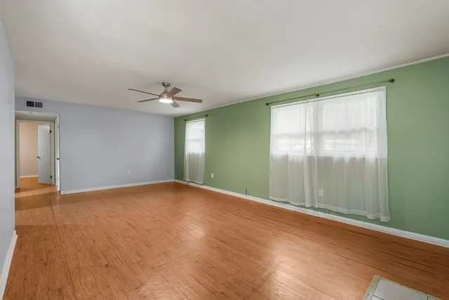 a view of an empty room with glass door and a window