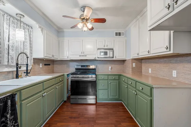 a kitchen with stainless steel appliances granite countertop a sink a stove top oven and cabinets