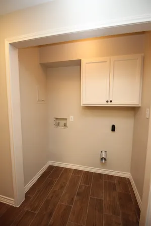 a view of a room with wooden floor and cabinets