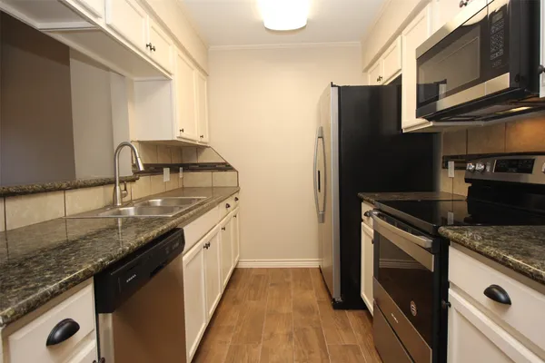 a kitchen with granite countertop stainless steel appliances and wooden cabinets