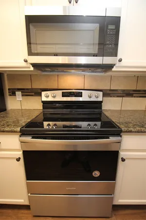 a stove top oven sitting inside of a kitchen