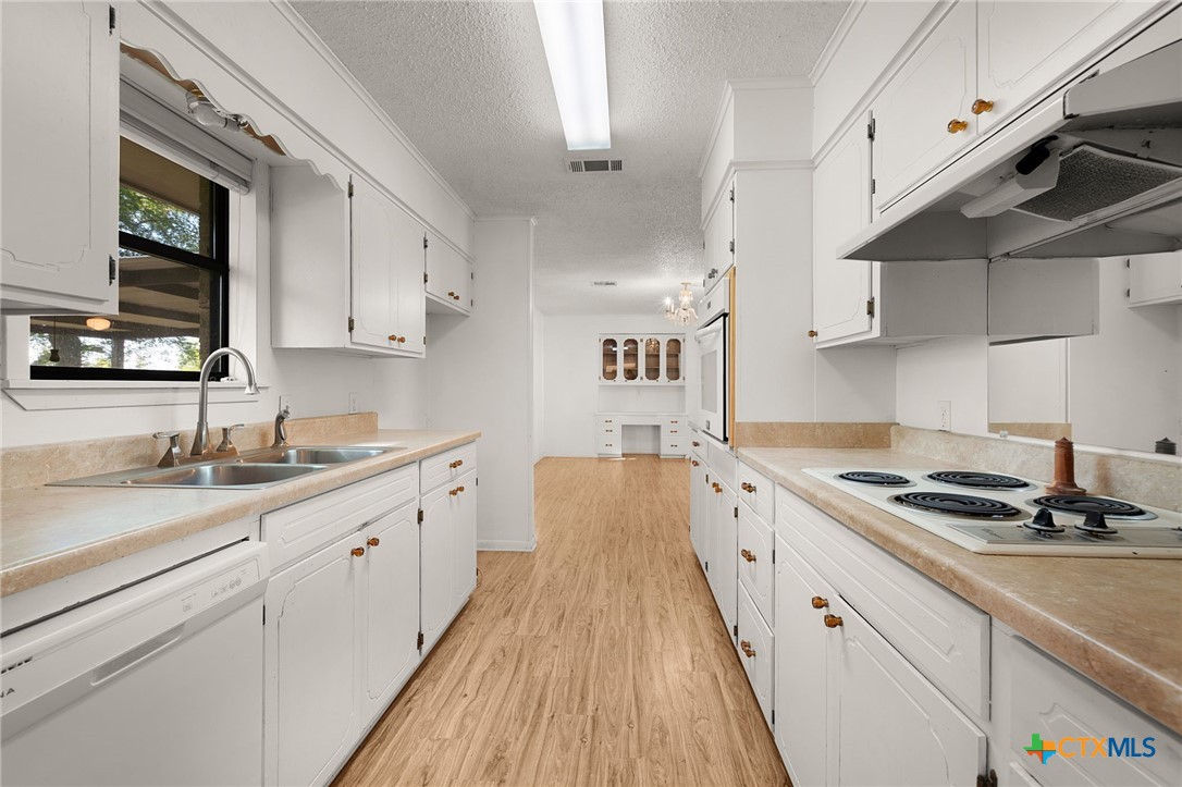 1830 Fm 221 Hamilton, TX 76531 - Photo 11 of 45 a kitchen with granite countertop a sink a stove and cabinets