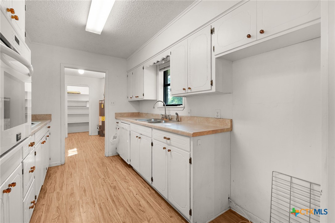 1830 Fm 221 Hamilton, TX 76531 - Photo 9 of 45 a large white kitchen with a sink a window and stainless steel appliances