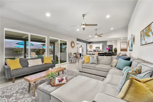 a living room with furniture kitchen and a chandelier