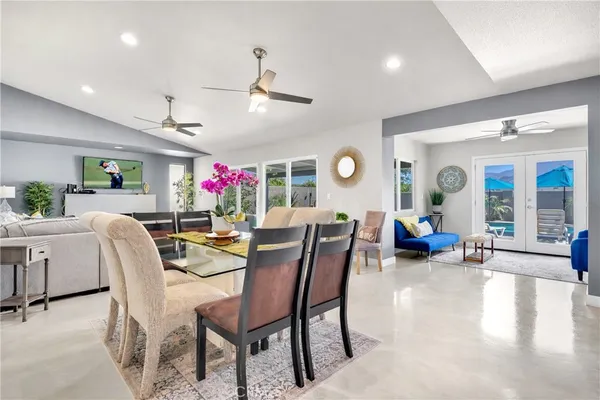 a dining room with wooden floor and chandelier