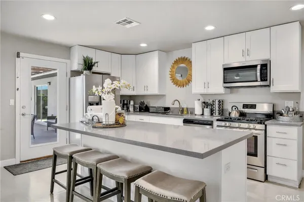 a kitchen with a sink a microwave and cabinets