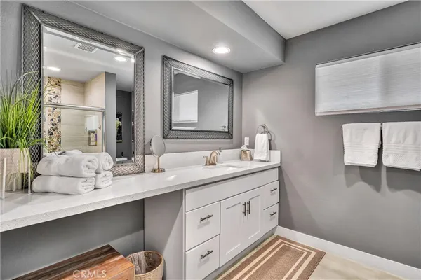 a spacious bathroom with a granite countertop sink and a mirror
