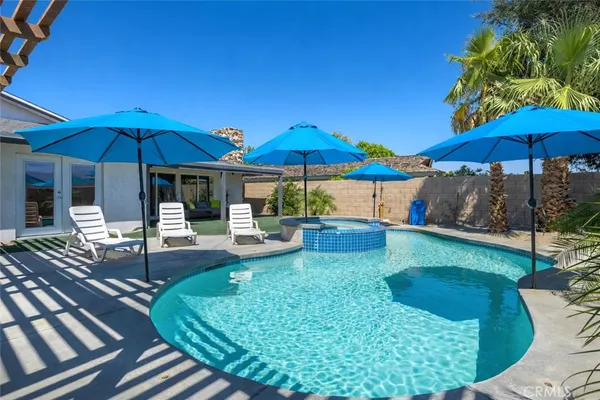 a patio with a table and chairs under an umbrella