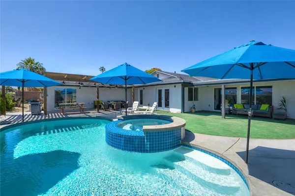 a view of a house with swimming pool and sitting area