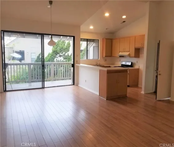 a kitchen with stainless steel appliances granite countertop a stove a sink and a refrigerator with wooden floor
