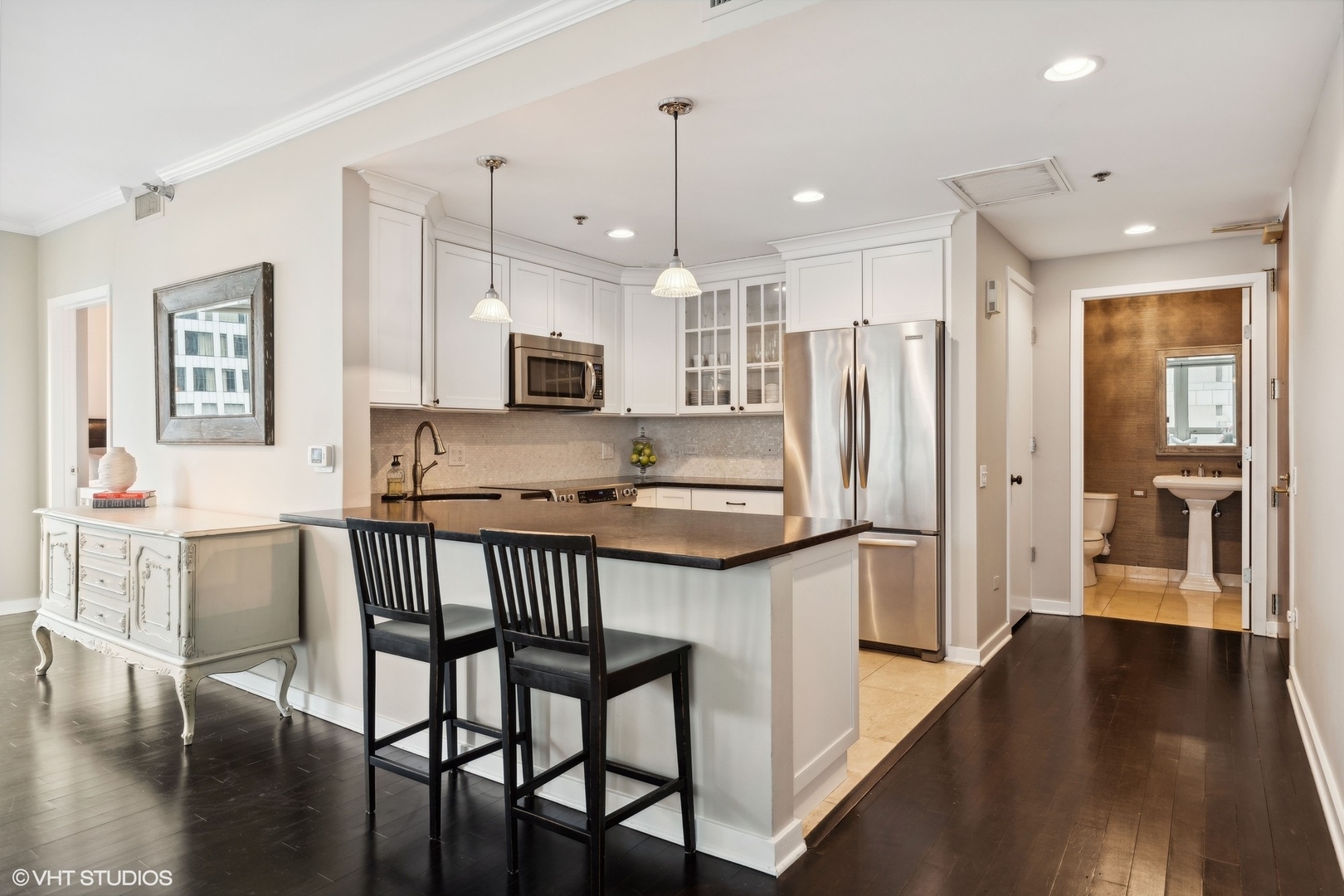 57 East Delaware Place, Unit 1801 Chicago, IL 60611 - Photo 5 of 19 a kitchen with stainless steel appliances granite countertop a refrigerator a stove a sink a dining table and chairs with wooden floor