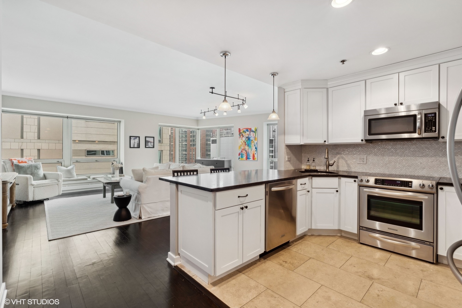 57 East Delaware Place, Unit 1801 Chicago, IL 60611 - Photo 6 of 19 a kitchen with stainless steel appliances granite countertop a stove top oven a sink dishwasher and white cabinets with wooden floor