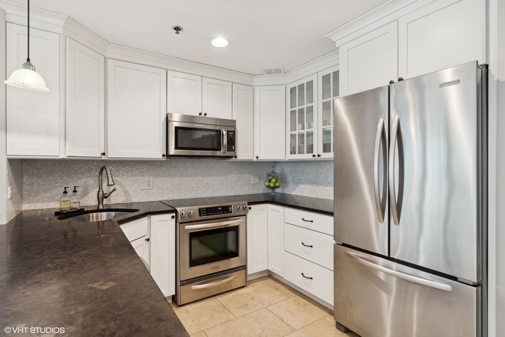 57 East Delaware Place, Unit 1801 Chicago, IL 60611 - Photo 7 of 19 a kitchen with white cabinets and stainless steel appliances