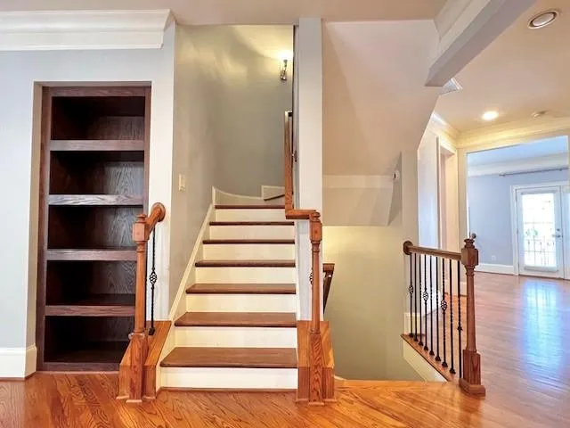 a view of a hallway with wooden floor and staircase