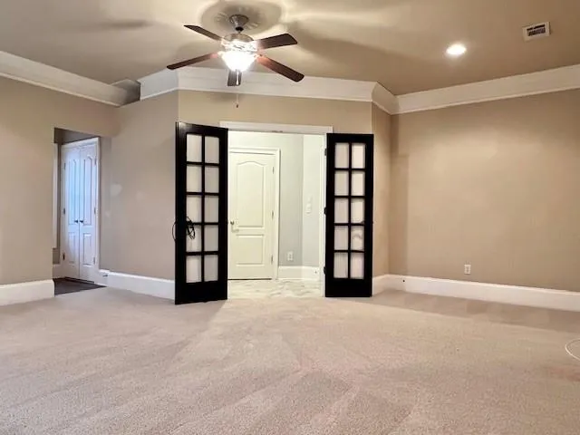 an empty room with windows and ceiling fan
