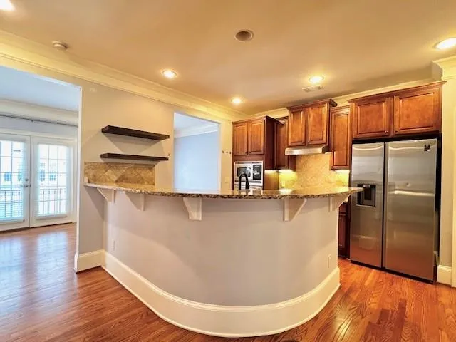 a view of a refrigerator in kitchen and wooden floor