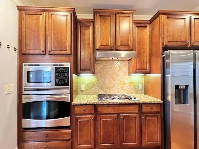 a kitchen with granite countertop cabinets stainless steel appliances and a counter space