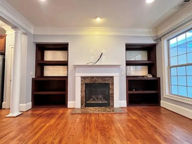 a view of an empty room with a fireplace and a window