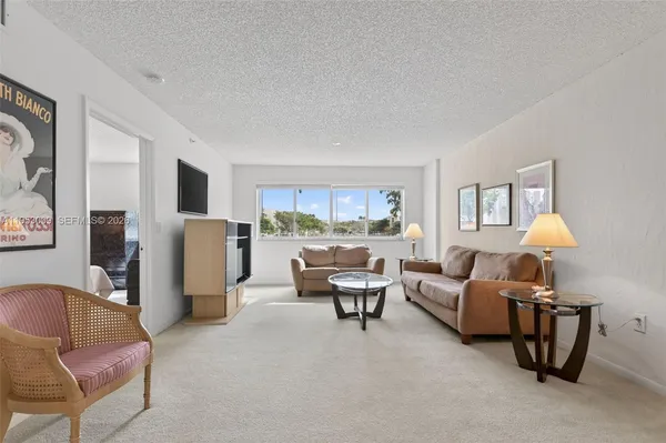a living room with furniture and a kitchen area