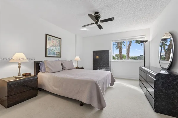 a bedroom with a bed a chandelier and a mirror