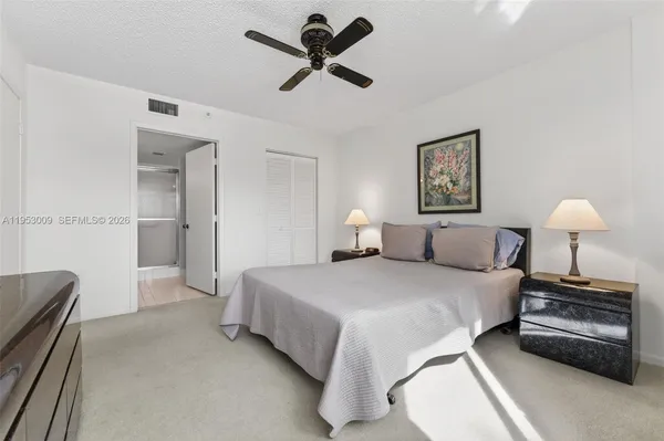 a bedroom with a bed and a lamp on the dresser