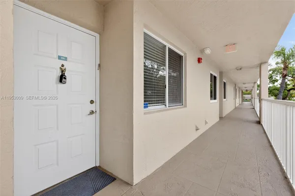a view of a hallway with wooden floor and windows