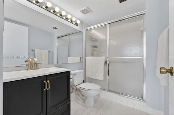 a bathroom with a sink toilet a mirror and shower