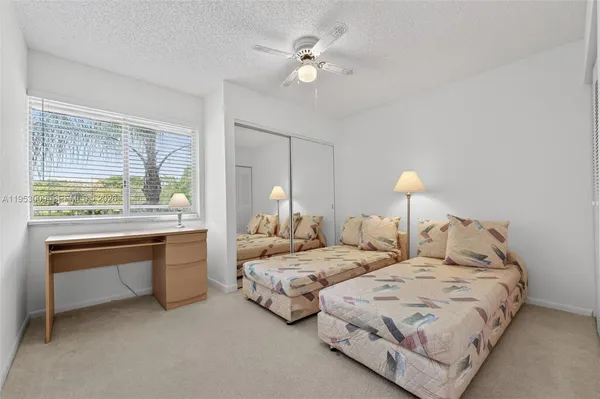 a bedroom with two bed and a large window