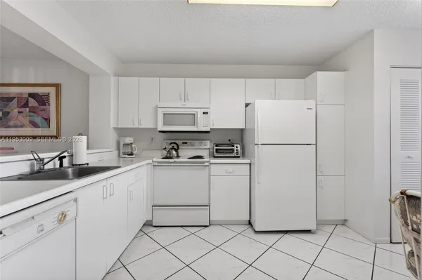 a kitchen with white cabinets and white appliances