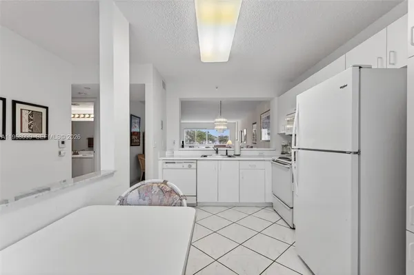 a kitchen with white cabinets and white appliances
