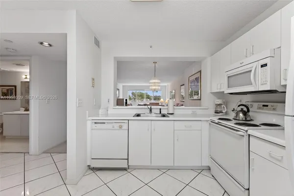 a kitchen with white cabinets appliances and a sink