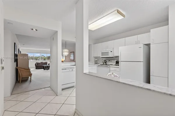 a kitchen with white cabinets and refrigerator
