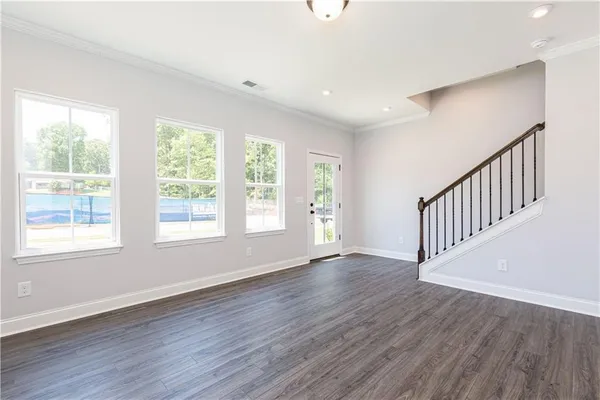 an empty room with wooden floor and windows