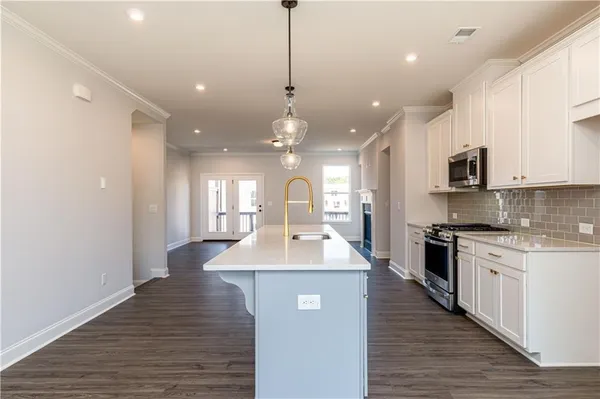 a kitchen with kitchen island a sink stainless steel appliances and cabinets