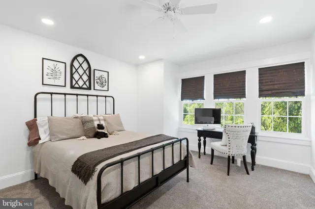 a bedroom with a bed and a large window