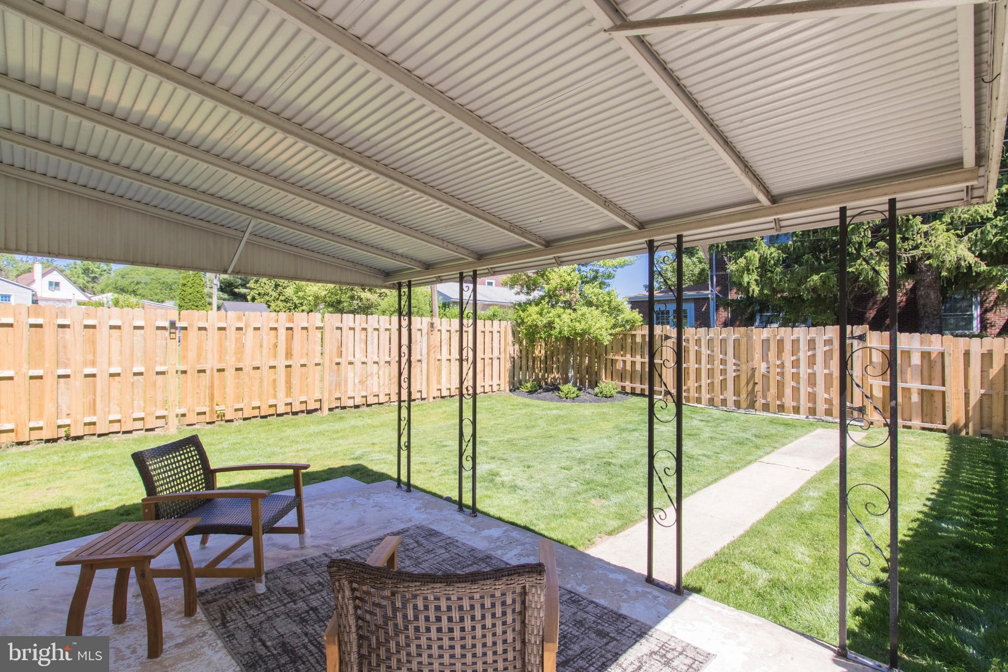 528 Lower E Valley Forge Road King of Prussia, PA 19406 - Photo 33 of 40 a view of a patio with table and chairs under an umbrella with a small yard