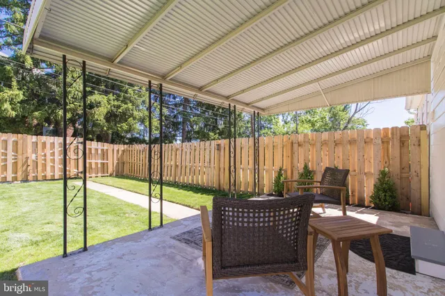 a view of a patio with table and chairs with wooden floor and fence