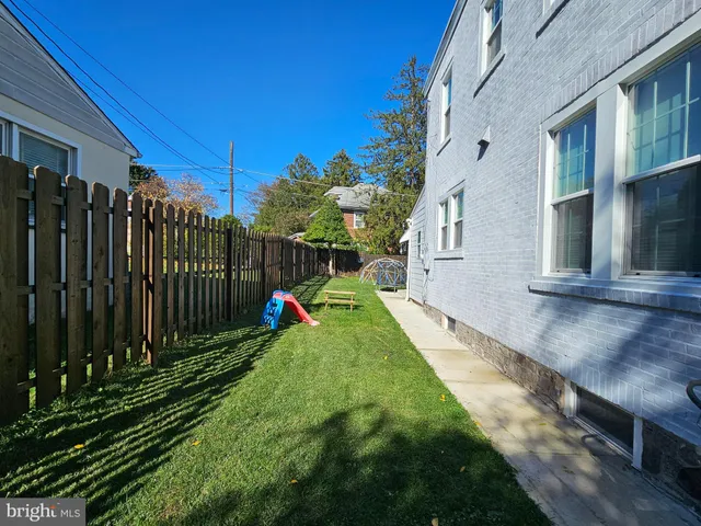a view of a backyard with brick wall and potted plants