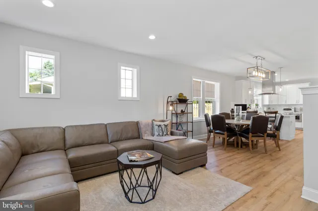 a living room with furniture kitchen view and a window