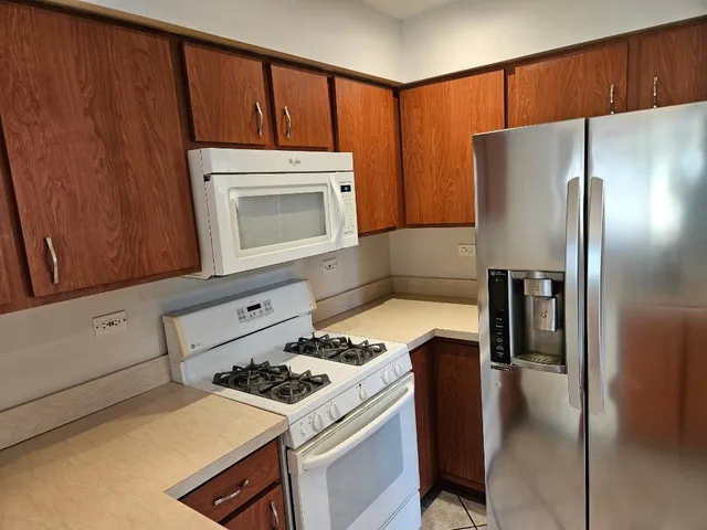 a kitchen with a stove a refrigerator and cabinets