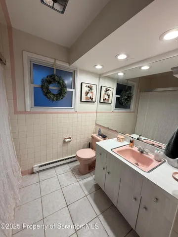 a bathroom with a granite countertop sink mirror vanity and toilet