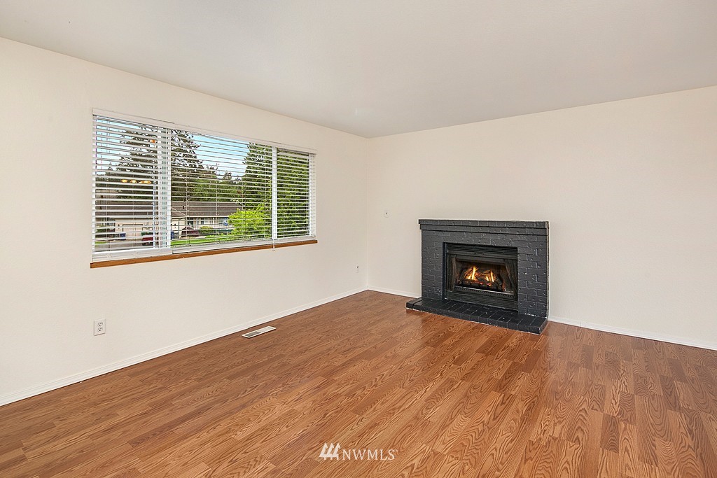 623 Harvest Road Bothell, WA 98012 - Photo 2 of 11 a view of an empty room with wooden floor and a window