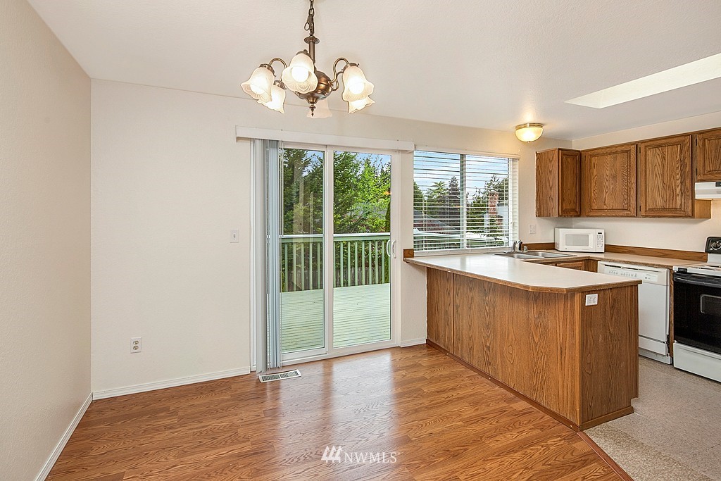 623 Harvest Road Bothell, WA 98012 - Photo 3 of 11 a kitchen with kitchen island granite countertop a stove a sink and wooden floors
