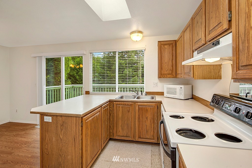 623 Harvest Road Bothell, WA 98012 - Photo 4 of 11 a kitchen with a sink a stove and white cabinets