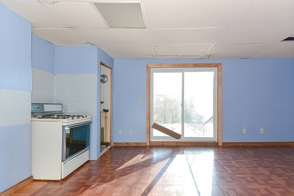 291 Sumner Street Boston, MA 02128 - Photo 24 of 41 a view of a kitchen with a stove wooden cabinets and a floor to ceiling window