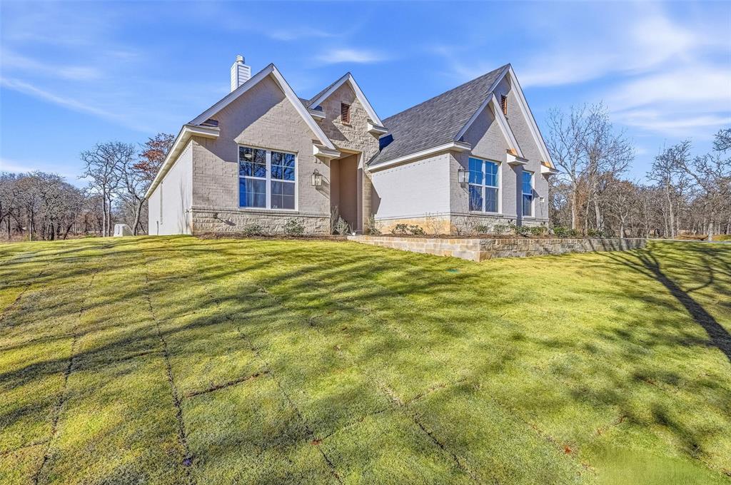 1053 Llano Way Poolville, TX 76487 - Photo 2 of 40 a front view of a house with a yard